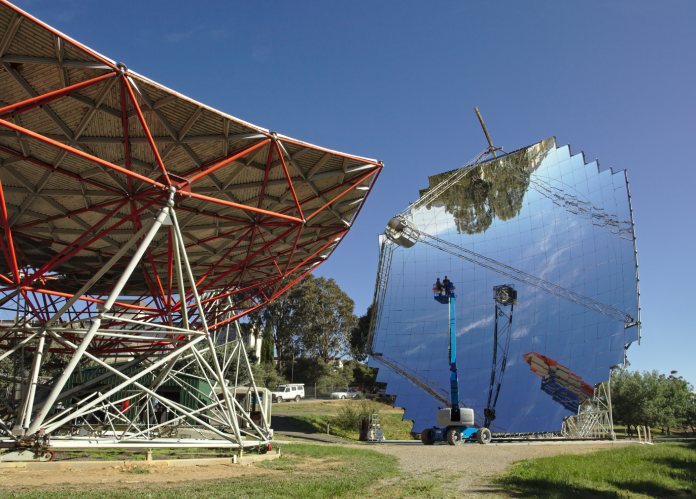 Plato gigante de espejos formando un paraboloide que concentra la energía térmica del sol en un punto, para hacer funcionar un motor térmico.