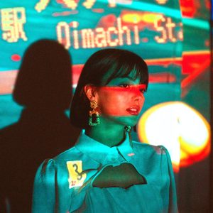 Mujer modelo frente a pantalla led y a proyección de colores